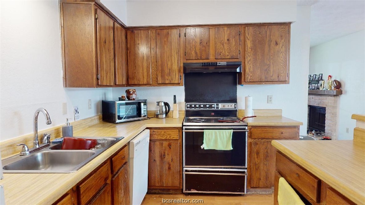 1005 Spring Loop, Unit D College Station, TX 77840 - Photo 9 of 25 a kitchen with a sink and a stove top oven