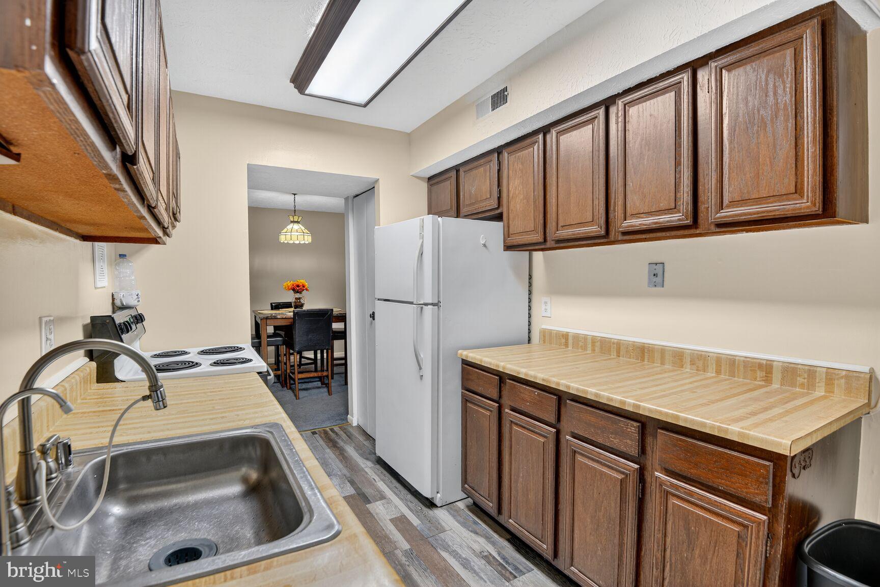 8007 Mandan Road, Unit 203 Greenbelt, MD 20770 - Photo 18 of 25 a kitchen with a sink a refrigerator and a stove top oven