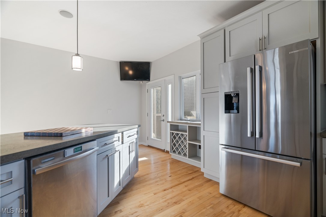 711 University Road Cleveland, OH 44113 - Photo 15 of 36 Kitchen with decorative light fixtures, light hardwood / wood-style flooring, appliances with stainless steel finishes, gray cabinets, and dark stone counters