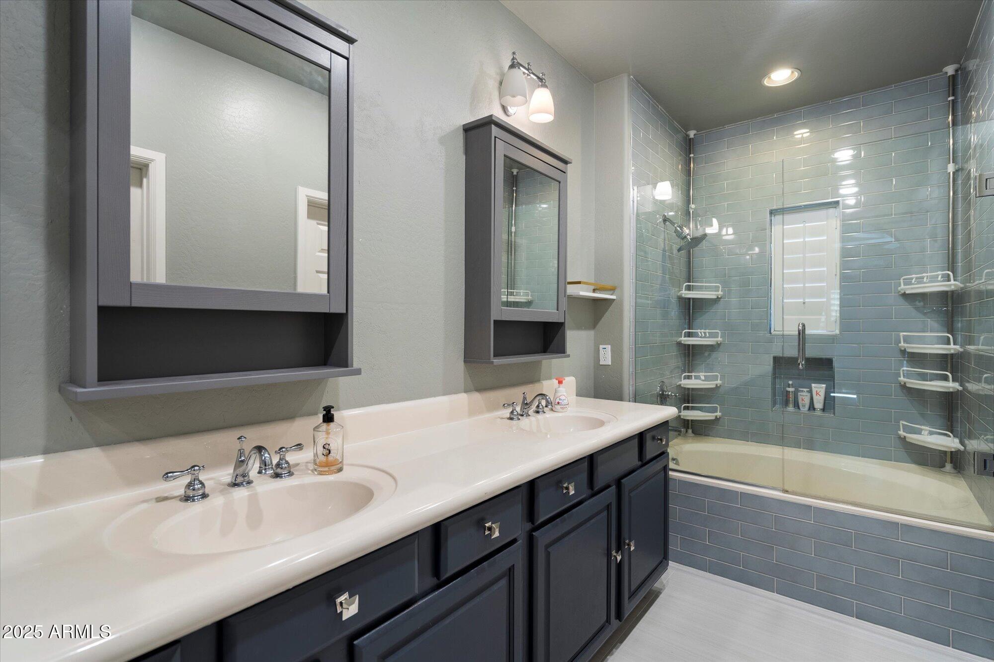 3935 East Rough Rider Road, Unit 1164 Phoenix, AZ 85050 - Photo 14 of 20 a bathroom with a sink double vanity granite tub shower and a mirror