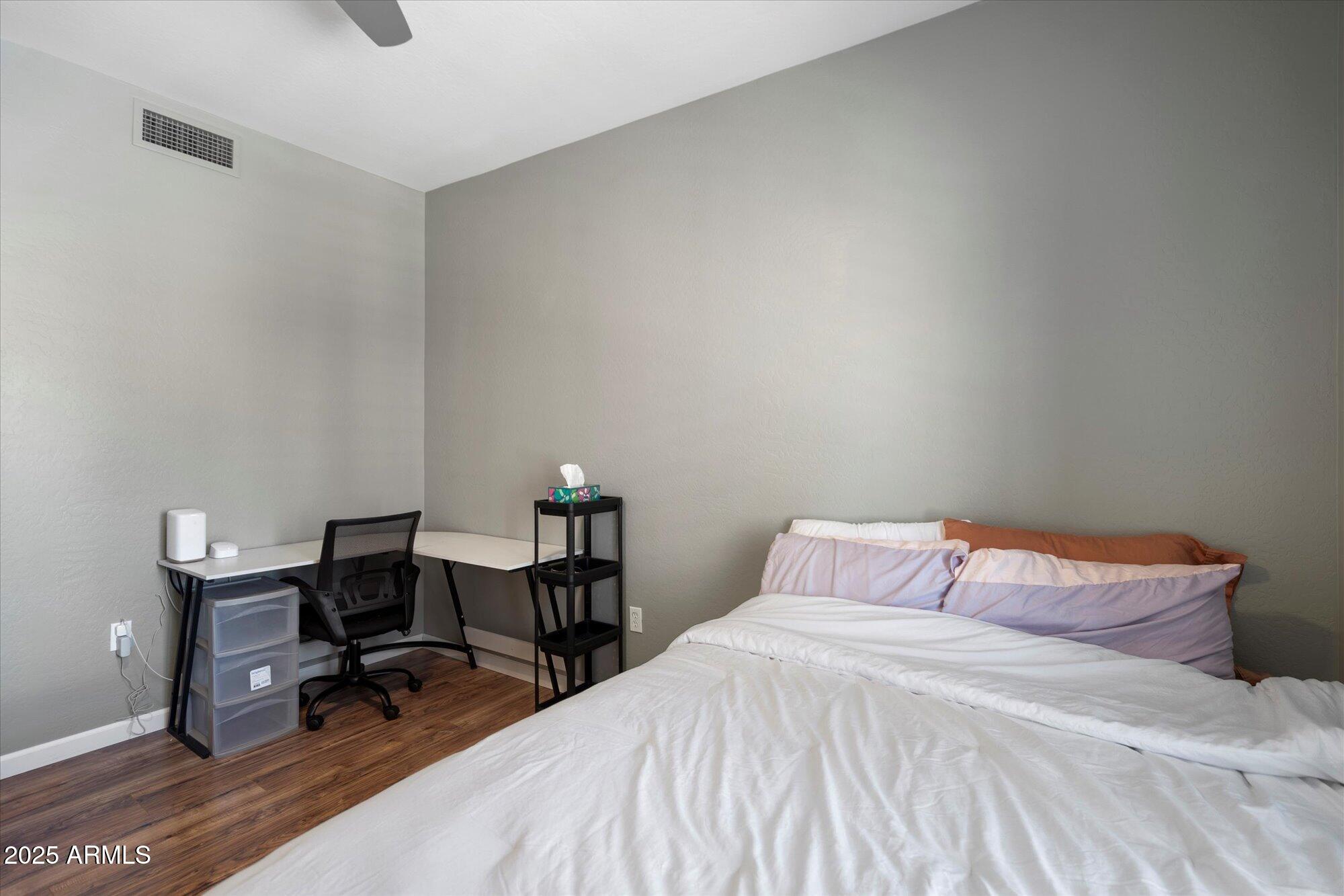 3935 East Rough Rider Road, Unit 1164 Phoenix, AZ 85050 - Photo 16 of 20 a bedroom with a bed a table and chair