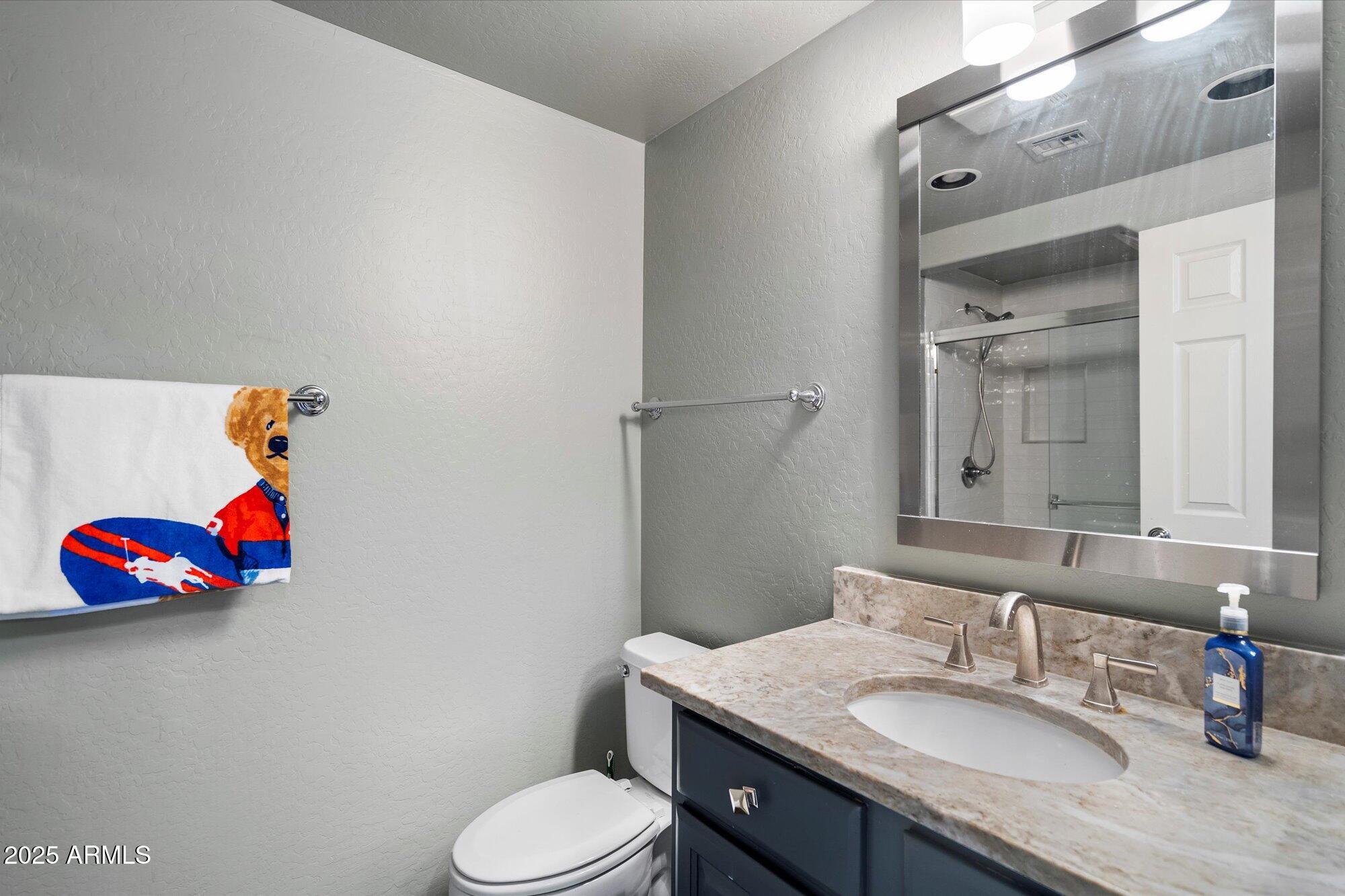 3935 East Rough Rider Road, Unit 1164 Phoenix, AZ 85050 - Photo 17 of 20 a bathroom with a granite countertop sink and a mirror