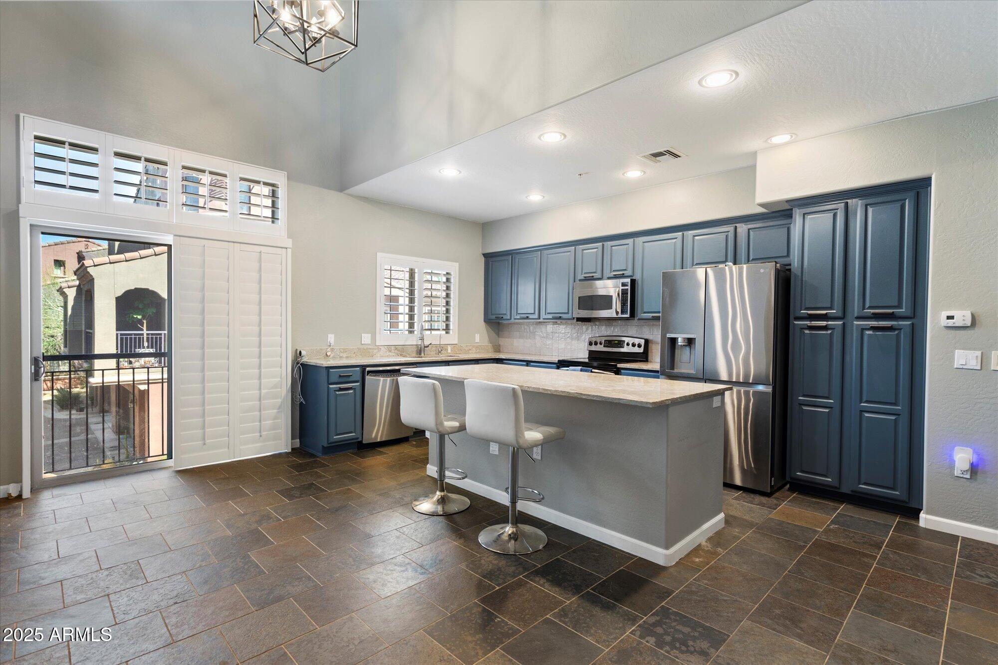 3935 East Rough Rider Road, Unit 1164 Phoenix, AZ 85050 - Photo 5 of 20 a kitchen with stainless steel appliances a refrigerator and a stove top oven