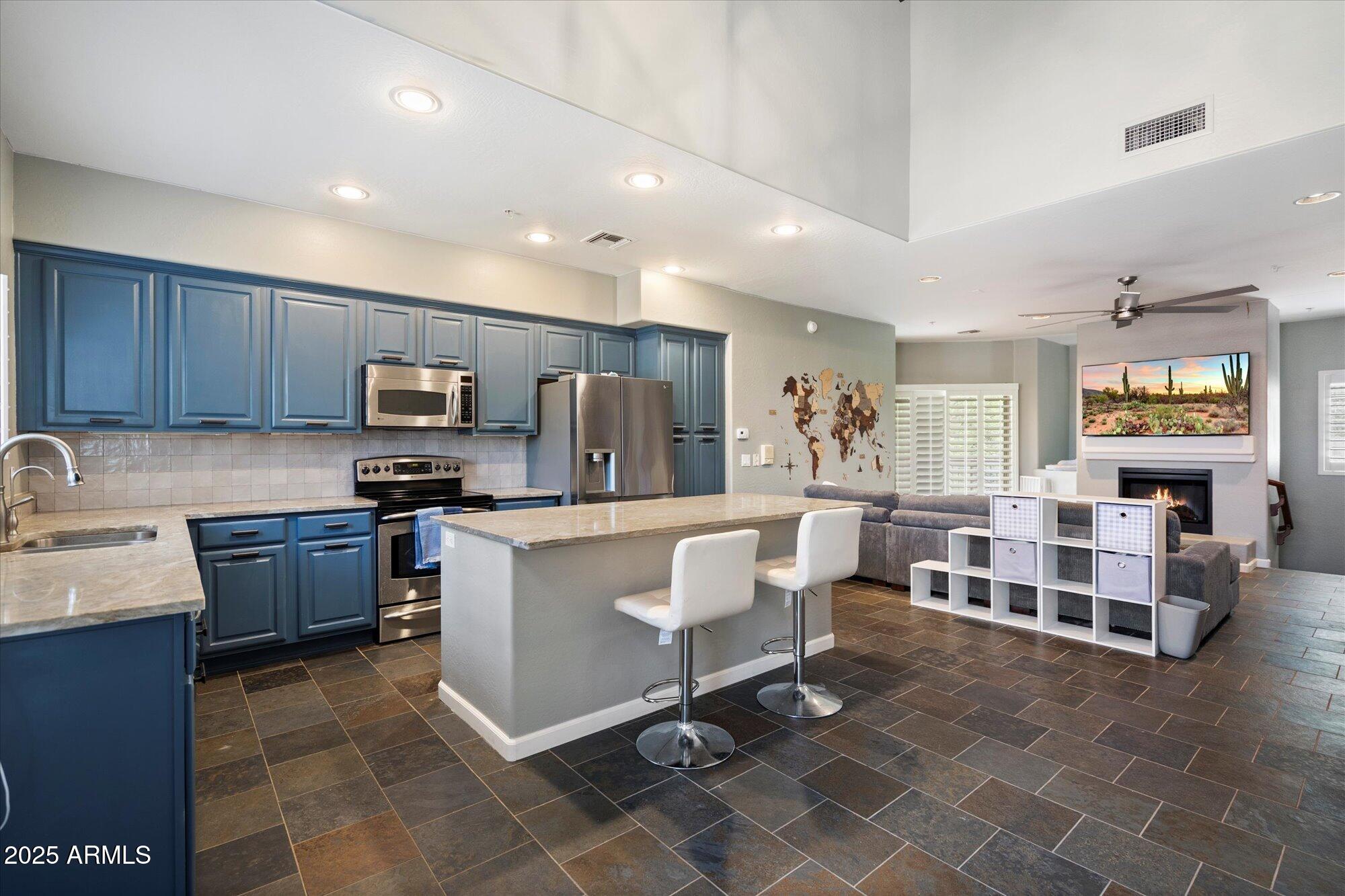 3935 East Rough Rider Road, Unit 1164 Phoenix, AZ 85050 - Photo 6 of 20 a kitchen with a refrigerator and furniture