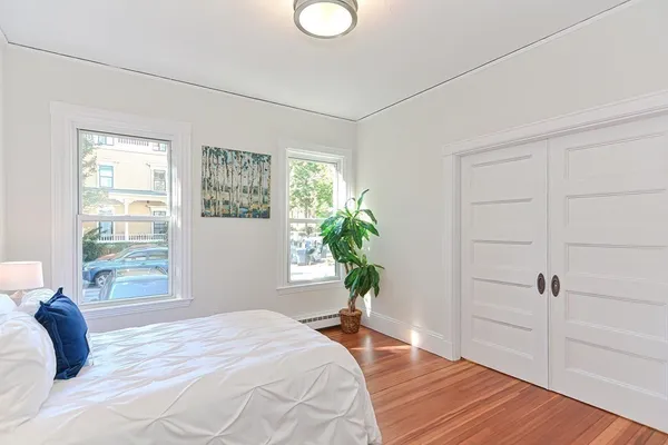 a bedroom with a bed and a potted plant