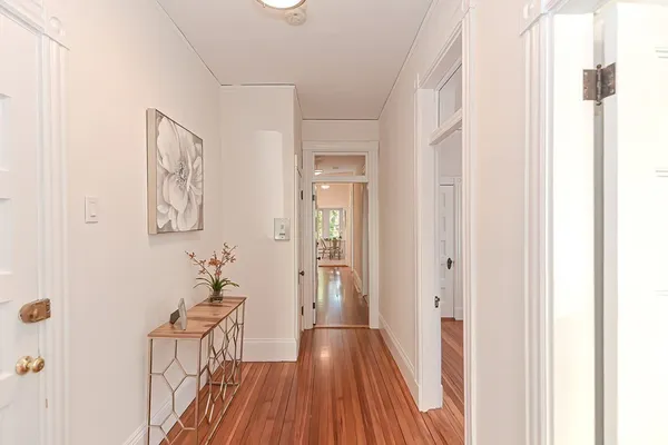 a view of a hallway with wooden floor and closet