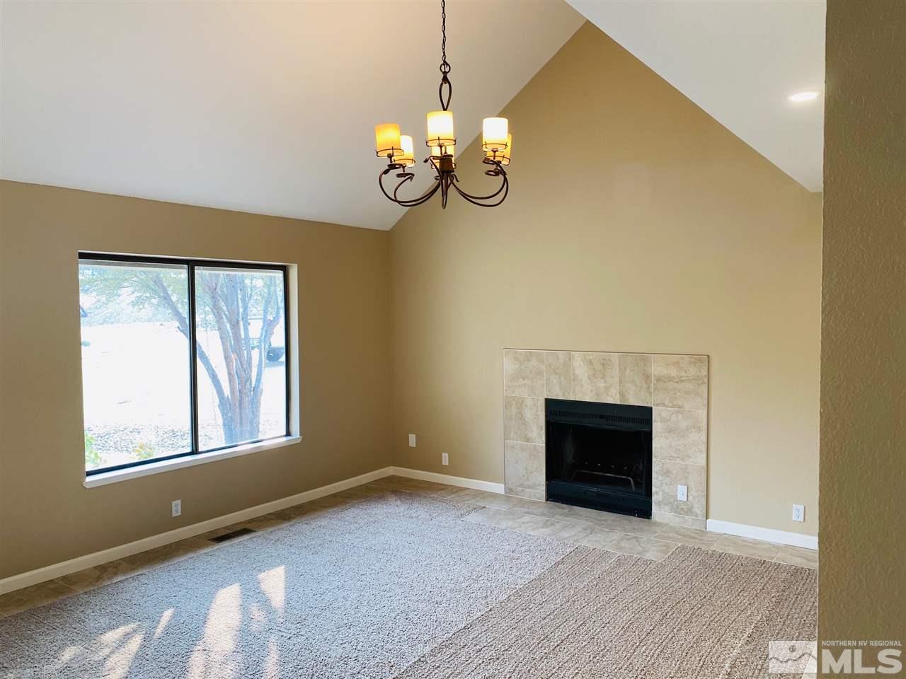 3899 Allen Glen Drive Reno, NV 89503 - Photo 3 of 13 a view of an empty room with a fireplace and a window
