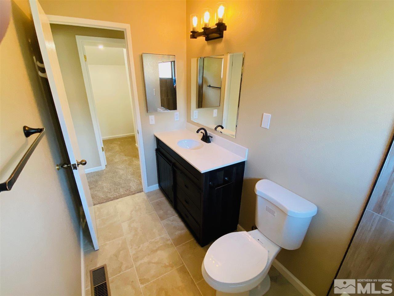 3899 Allen Glen Drive Reno, NV 89503 - Photo 9 of 13 a bathroom with a sink a toilet a mirror and vanity