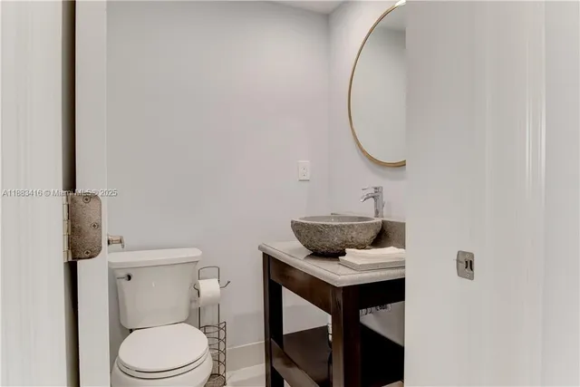 a bathroom with a toilet a sink and a mirror