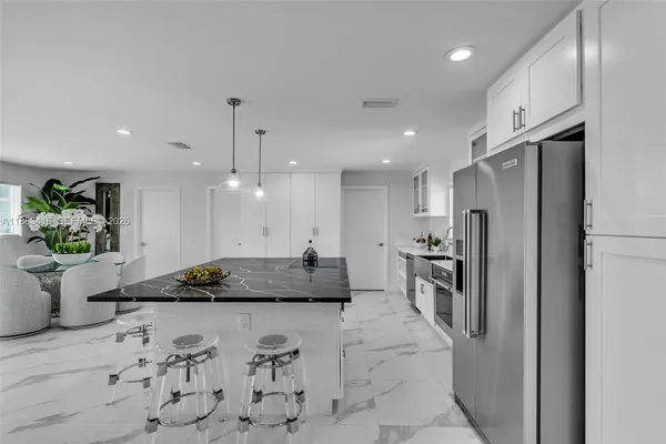 a kitchen with a refrigerator a stove and a sink