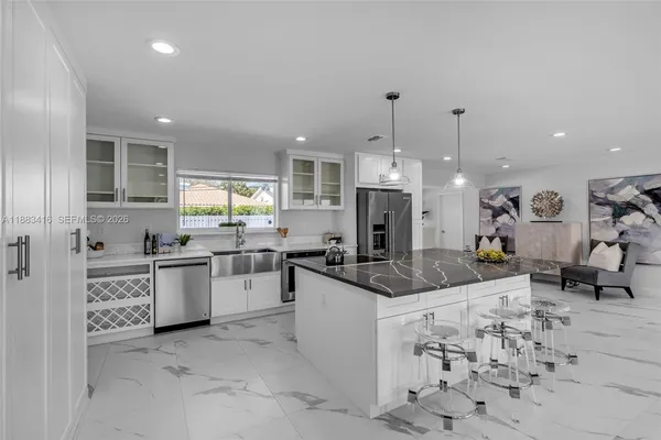 a kitchen with stainless steel appliances kitchen island granite countertop a sink and cabinets