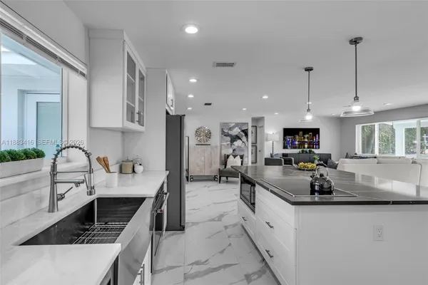 a large kitchen with stainless steel appliances lots of counter space and a sink