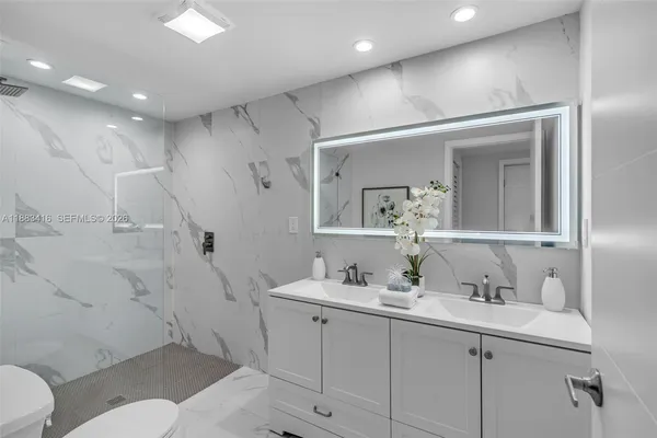 a bathroom with a granite countertop sink mirror and toilet