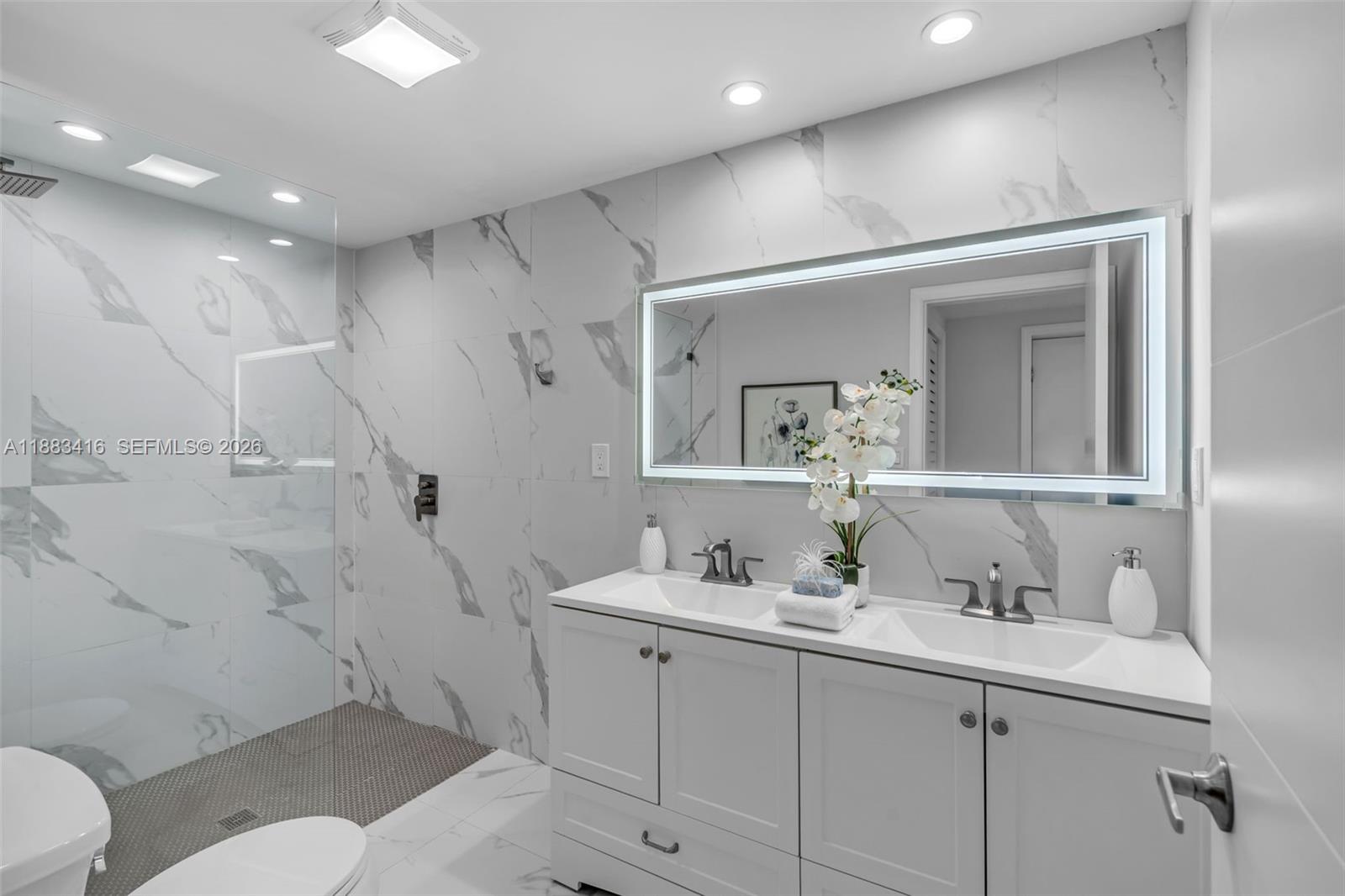 465 Northwest 11th Street Boca Raton, FL 33432 - Photo 25 of 50 a bathroom with a granite countertop sink mirror and toilet