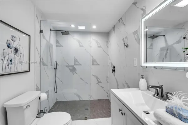 a bathroom with a sink toilet vanity and shower