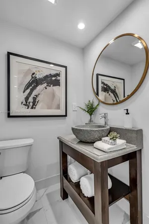 a bathroom with a toilet a sink and mirror