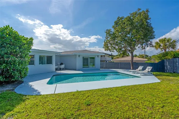 a view of a house with backyard and a tree
