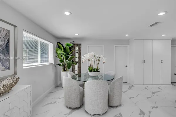 a dining room with furniture and potted plant