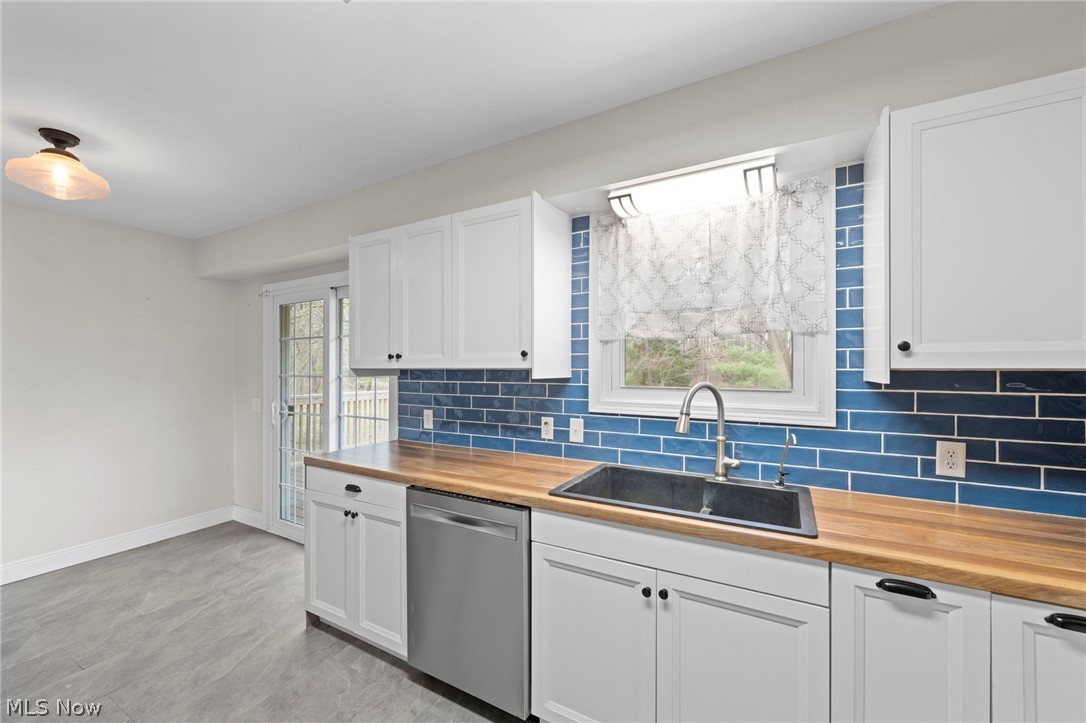 1835 Windham Road Newton Falls, OH 44444 - Photo 13 of 40 Kitchen with wood counters, stainless steel dishwasher, and tasteful backsplash