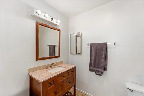 a bathroom with a granite countertop sink toilet a mirror and shower