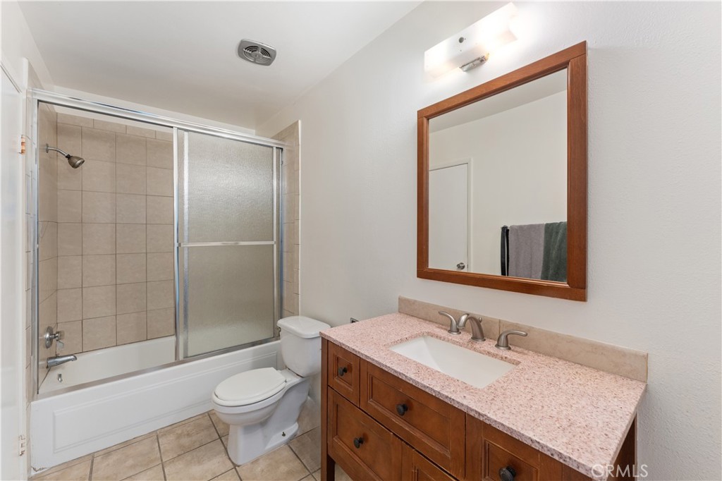 14802 Newport Avenue, Unit 18A Tustin, CA 92780 - Photo 15 of 27 a bathroom with a granite countertop sink toilet a mirror and shower