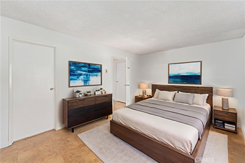14802 Newport Avenue, Unit 18A Tustin, CA 92780 - Photo 16 of 27 a bedroom with a bed and a lamp on table