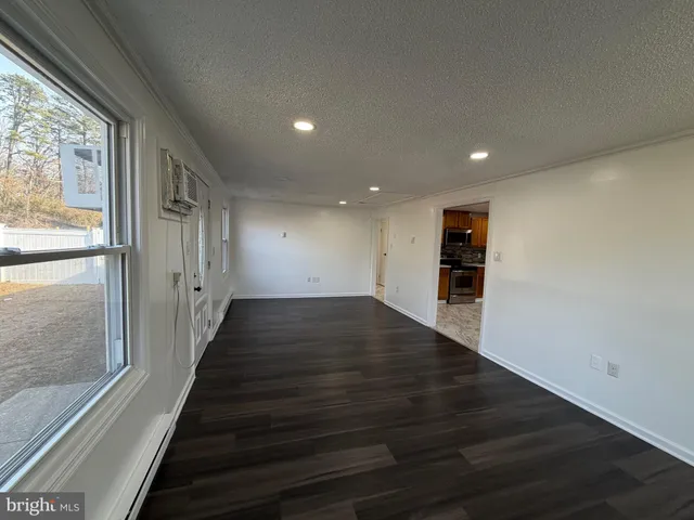 a view of a hallway with wooden floor and stairs