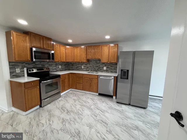 a kitchen with stainless steel appliances granite countertop a stove top oven a sink dishwasher a refrigerator and a microwave