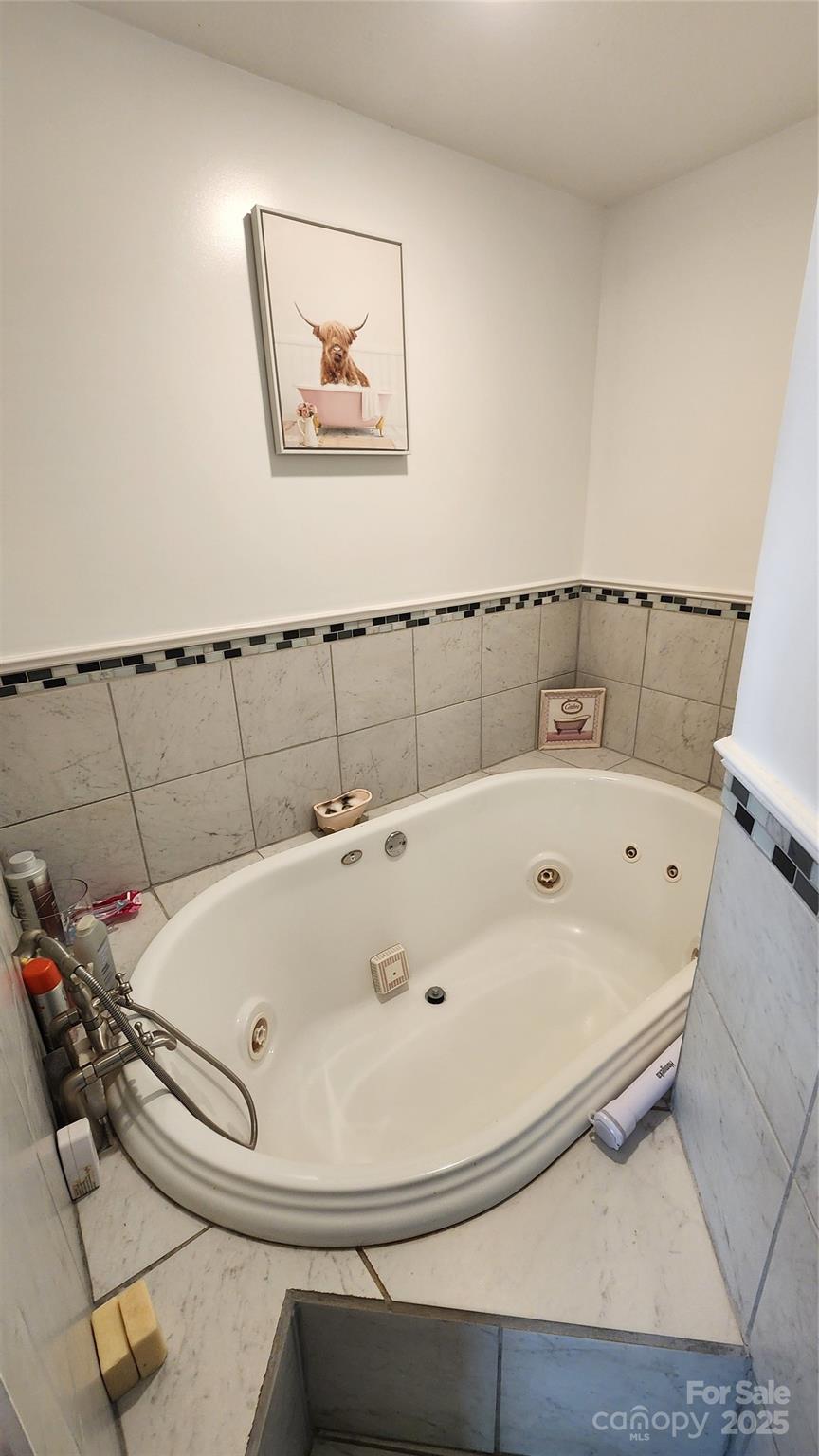 1235 Sulphur Springs Road Waynesville, NC 28786 - Photo 12 of 40 a bathroom with a tub and a painting on the wall