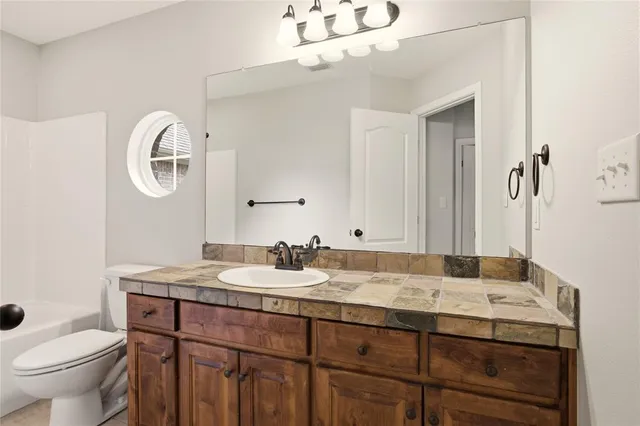 a bathroom with a granite countertop double vanity sink and a mirror