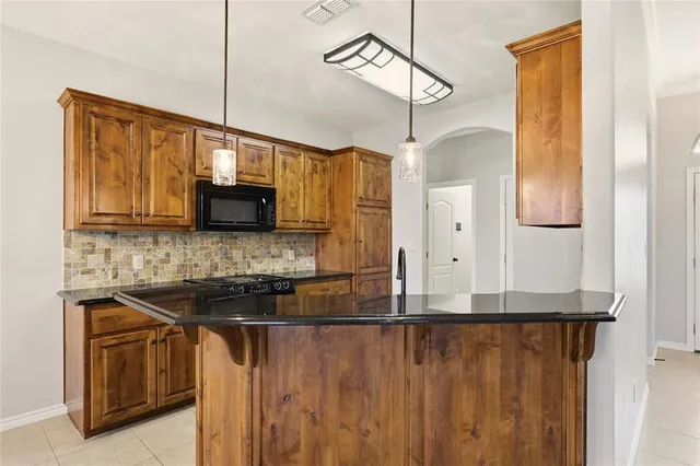 a kitchen with stainless steel appliances granite countertop a stove a sink and a microwave
