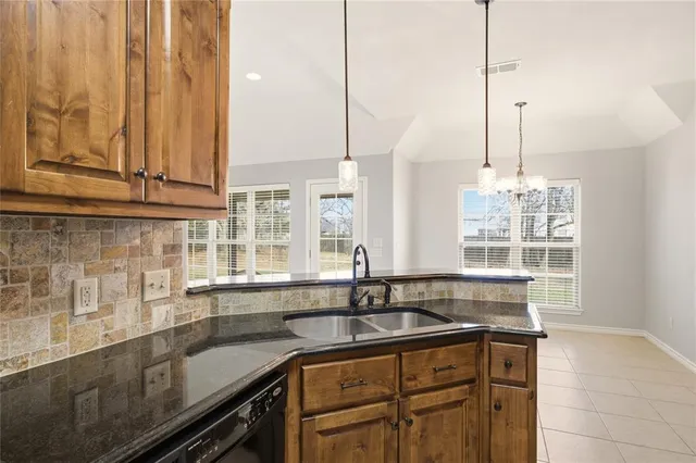 a kitchen with stainless steel appliances granite countertop a sink a counter space and cabinets