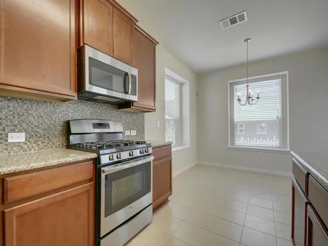 a kitchen with cabinets stainless steel appliances and a sink