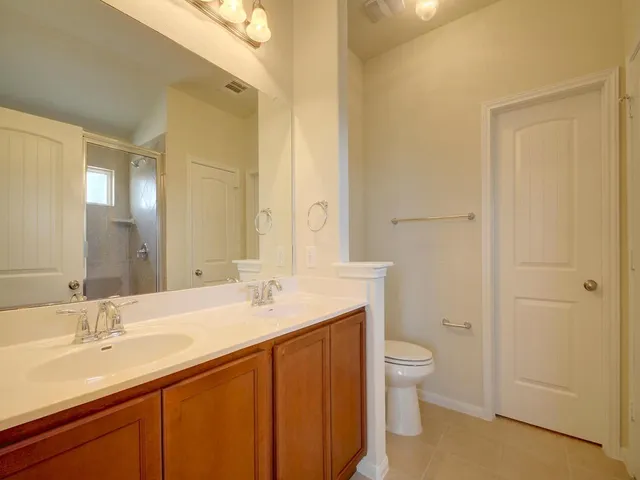 a bathroom with a granite countertop sink a toilet and a large mirror