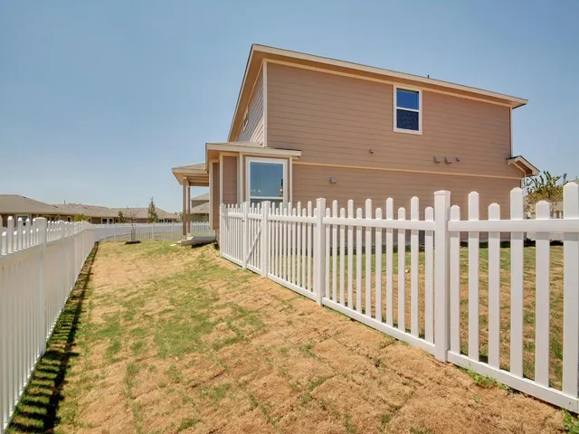 a view of a house with wooden fence