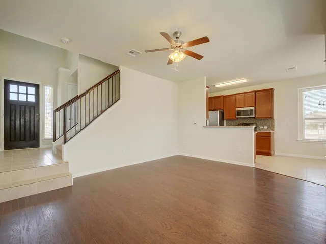 a view of a livingroom with wooden floor and staircase