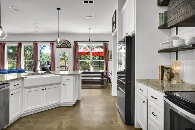 a kitchen with granite countertop a sink stainless steel appliances and cabinets