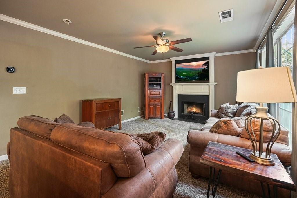7335 Lytham Trace Cumming, GA 30041 - Photo 15 of 45 a living room with furniture a fireplace and a flat screen tv