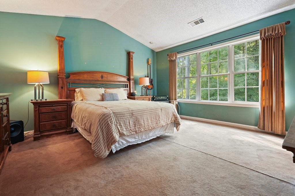 7335 Lytham Trace Cumming, GA 30041 - Photo 20 of 45 a bedroom with a bed lamp and a large window