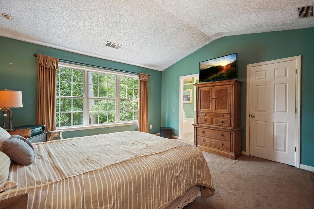 7335 Lytham Trace Cumming, GA 30041 - Photo 21 of 45 a bedroom with a bed and a dresser
