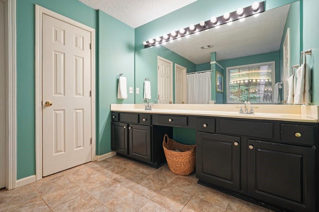 7335 Lytham Trace Cumming, GA 30041 - Photo 22 of 45 a bathroom with a tub a sink double vanity and a mirror