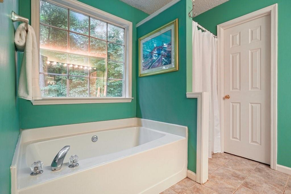 7335 Lytham Trace Cumming, GA 30041 - Photo 24 of 45 a bathroom with a bathtub and window