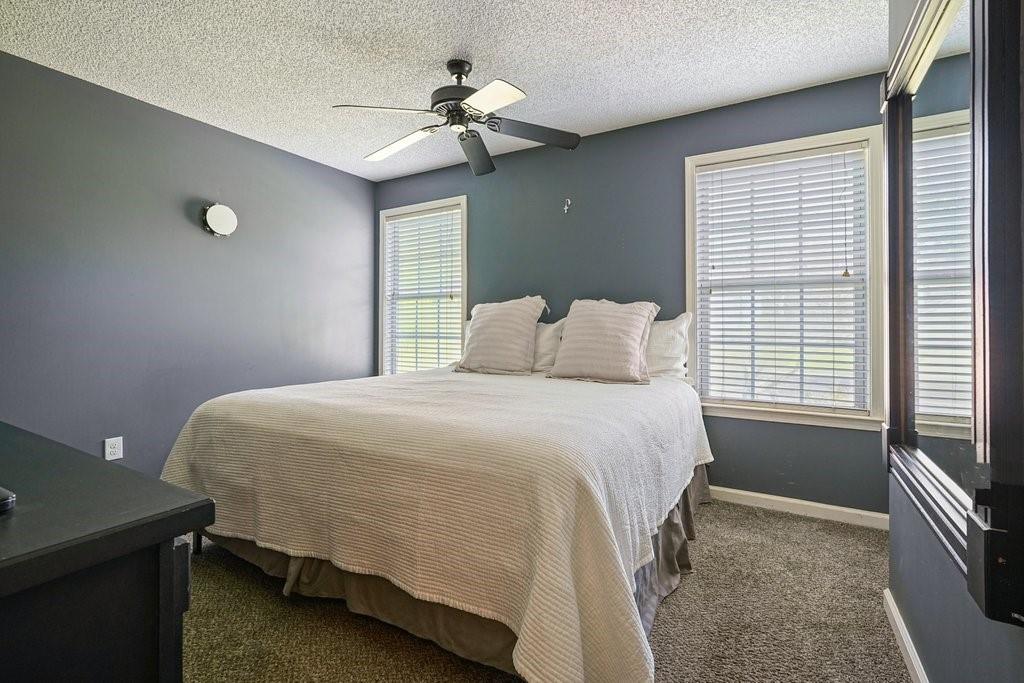 7335 Lytham Trace Cumming, GA 30041 - Photo 25 of 45 a bedroom with a bed and a chandelier