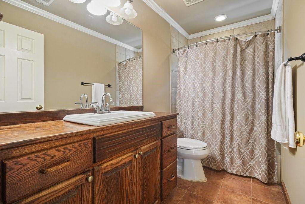 7335 Lytham Trace Cumming, GA 30041 - Photo 27 of 45 a bathroom with a sink a toilet and shower curtain