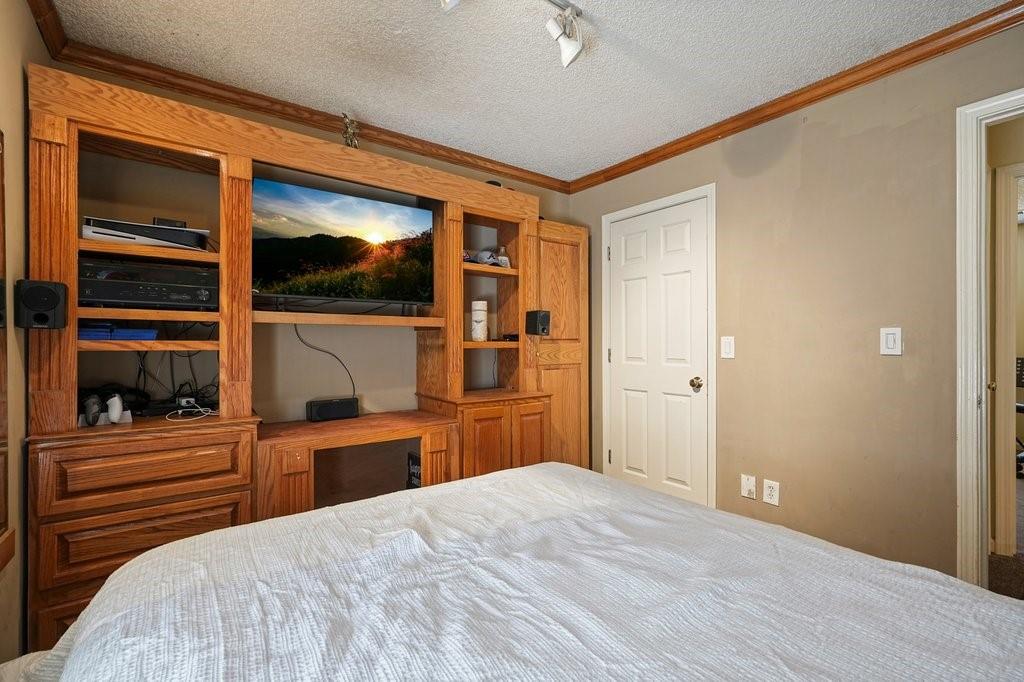 7335 Lytham Trace Cumming, GA 30041 - Photo 29 of 45 a bedroom with a bed and a flat screen tv