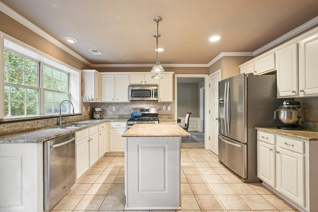 7335 Lytham Trace Cumming, GA 30041 - Photo 6 of 45 a kitchen with stainless steel appliances granite countertop a stove top oven a refrigerator a sink and dishwasher