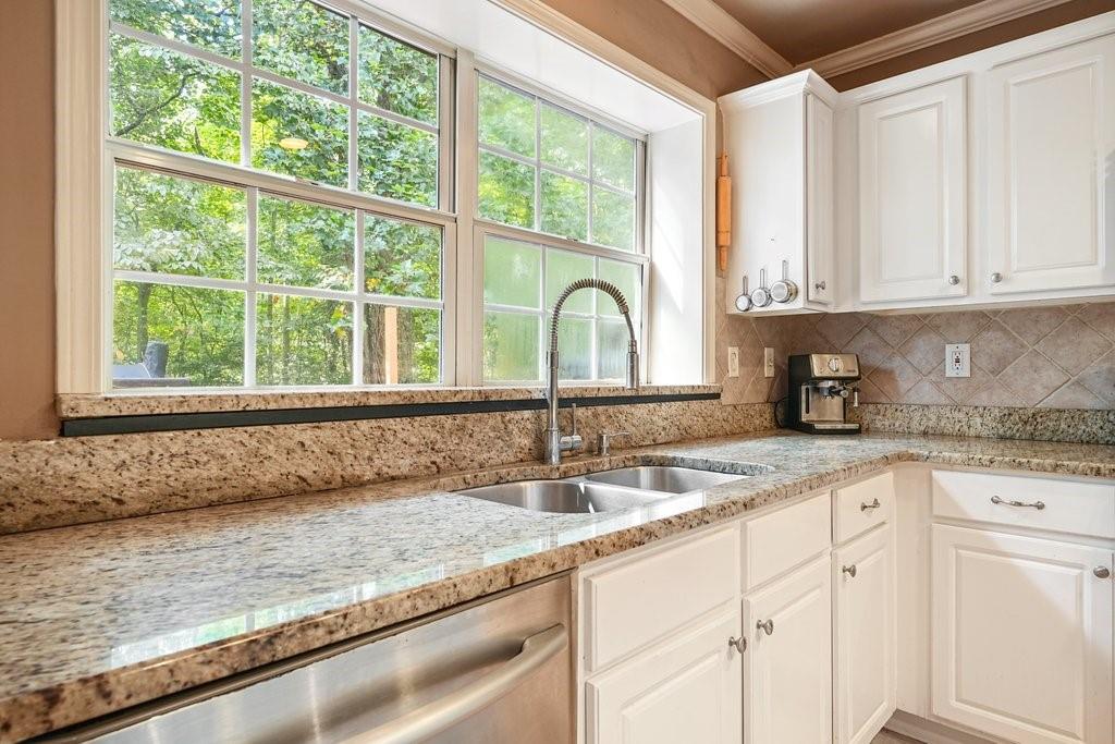 7335 Lytham Trace Cumming, GA 30041 - Photo 9 of 45 a kitchen with granite countertop a sink and white cabinets