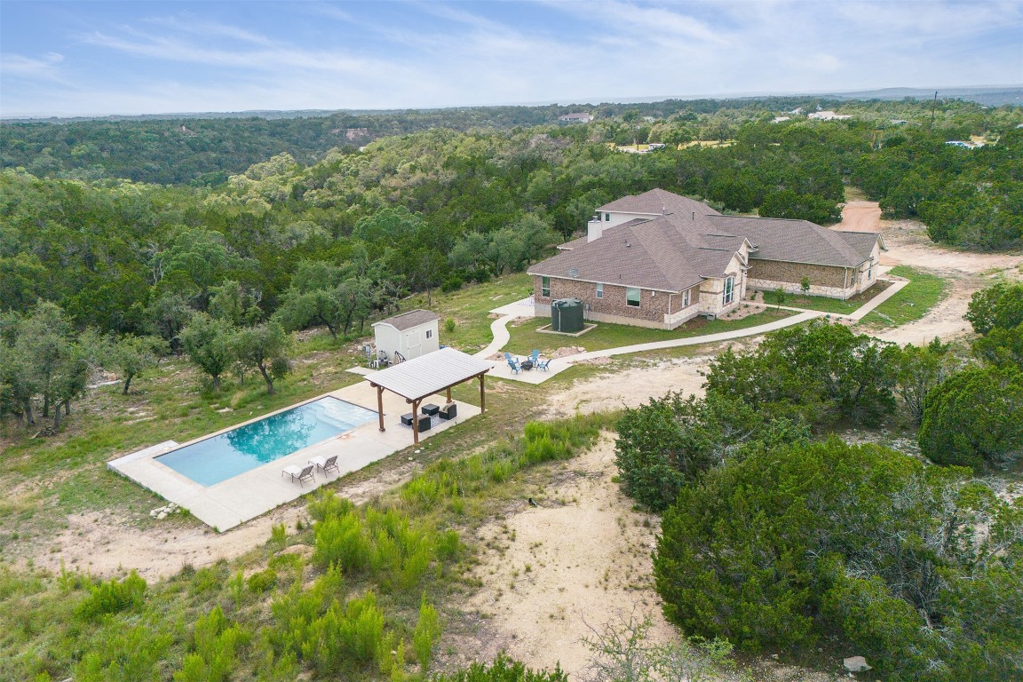 an aerial view of a house with a garden and lake view