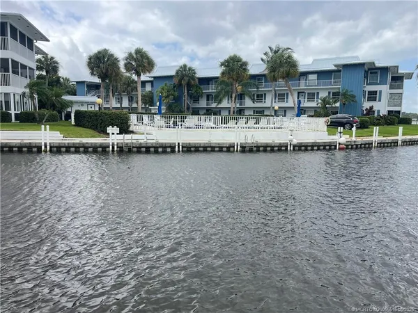 a view of a lake with a house and swimming pool