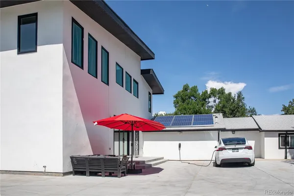 a front view of a house with sitting space and trees